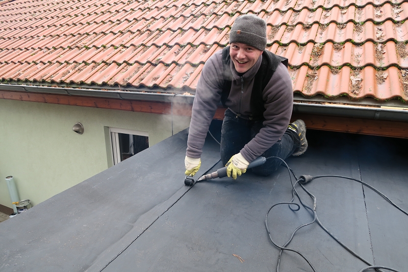 Paul Lindstedt als Dachdecker beim Verschweißen der Decklage eines Flachdachcarports.