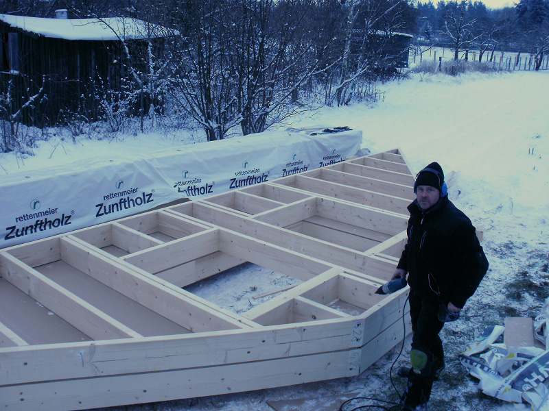 Trotz Wintereinbruch wird gearbeitet. Thomas Sedmihradsky montiert eine Holzrahmenwand.